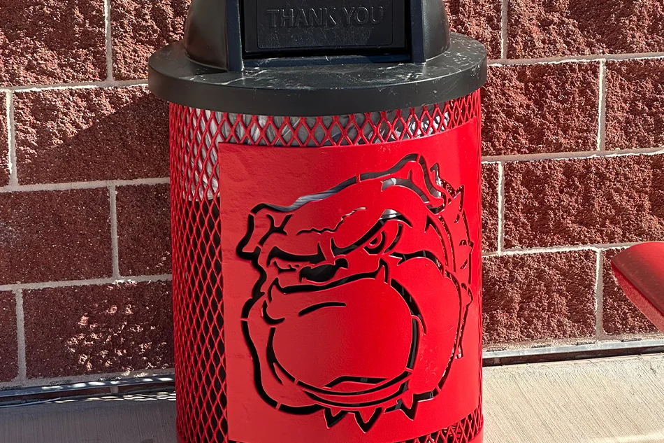 An outdoor trash can with a red bulldog