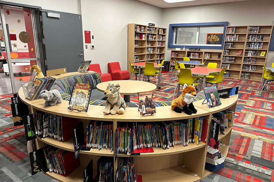 a round bookshelf with a couch on one side in a library