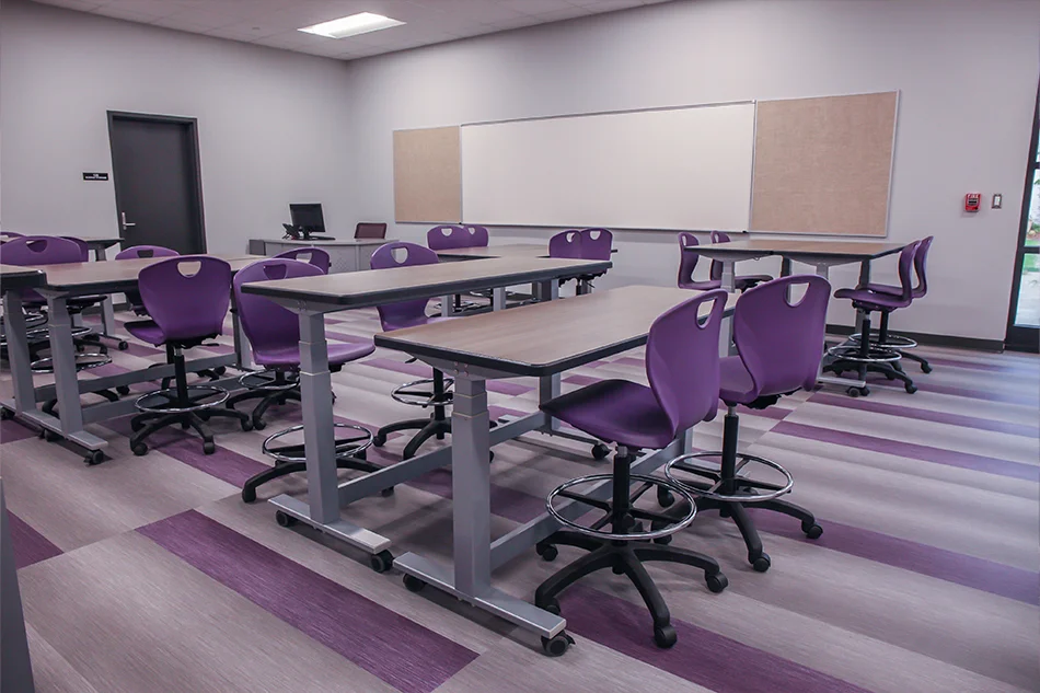 Adjustable student tables with purple rolling chairs