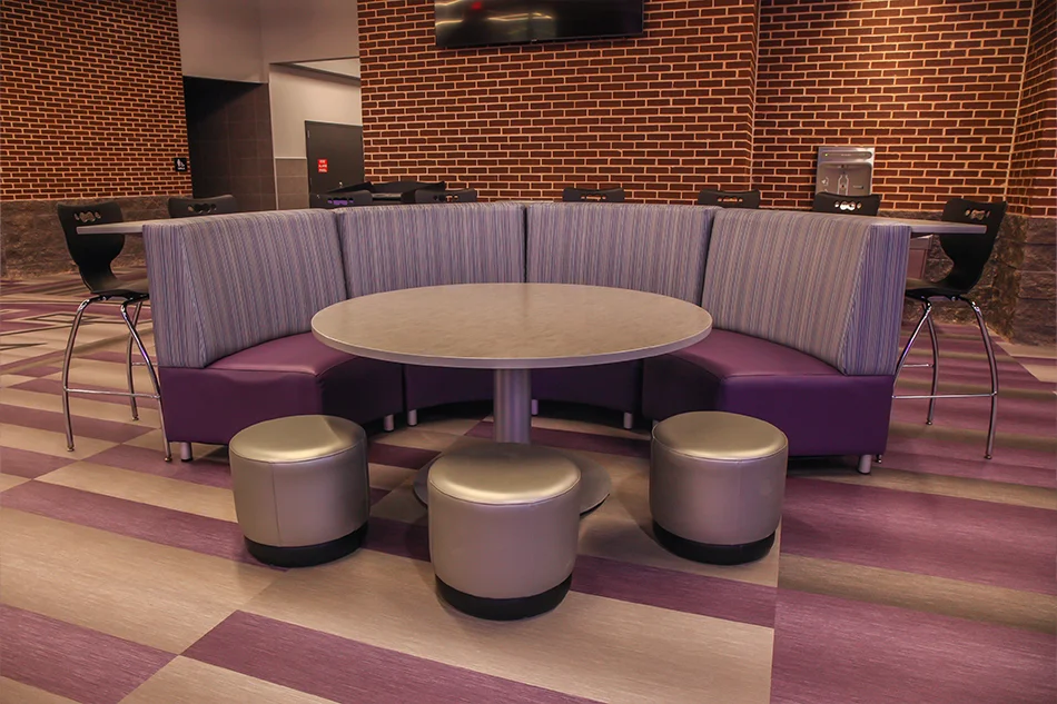 A round student sitting couch with a round table and ottomans