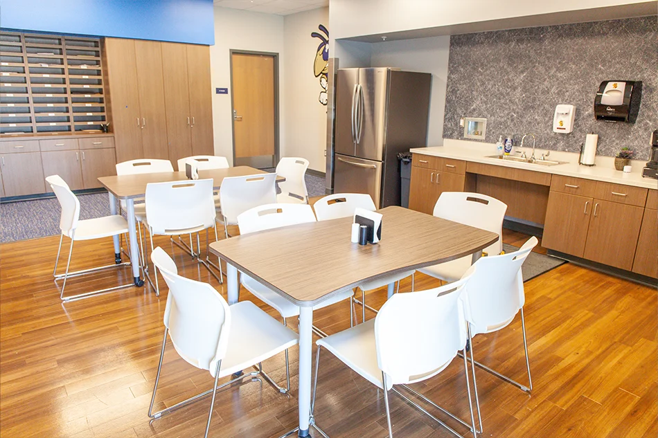 Teacher's lounge with tables and white chairs