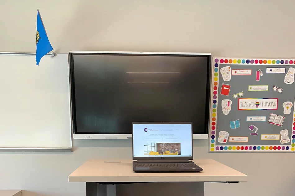 A laptop sitting on a high-top table in front of a smart projector