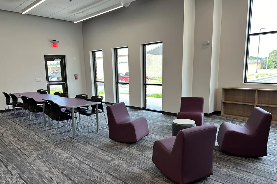 A student sitting area with purple chairs and a long table