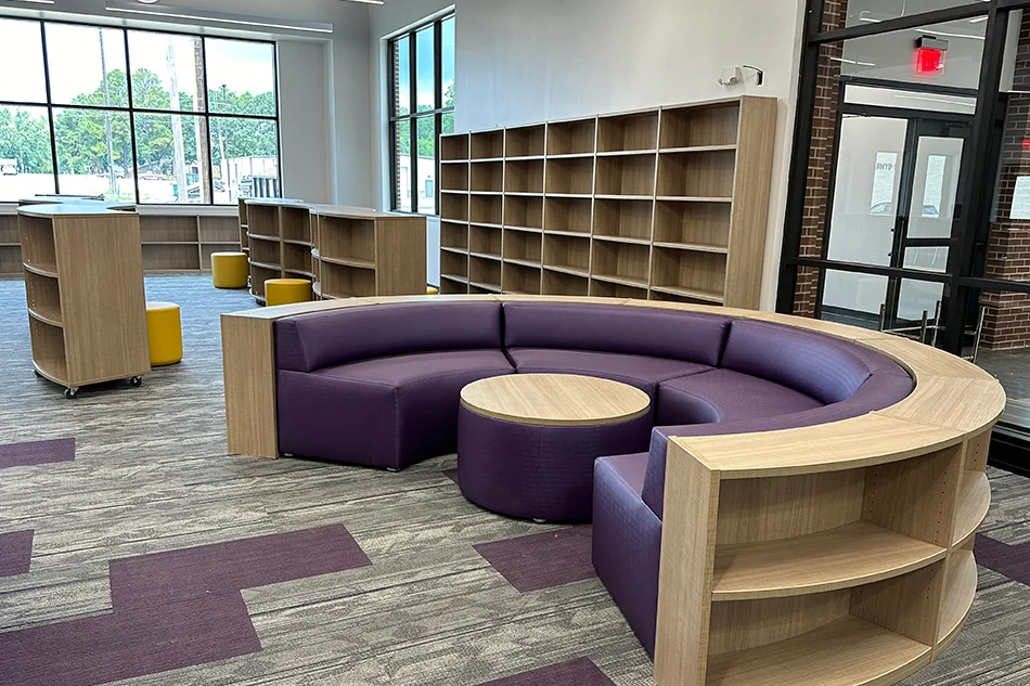 A round purple couch in a school library