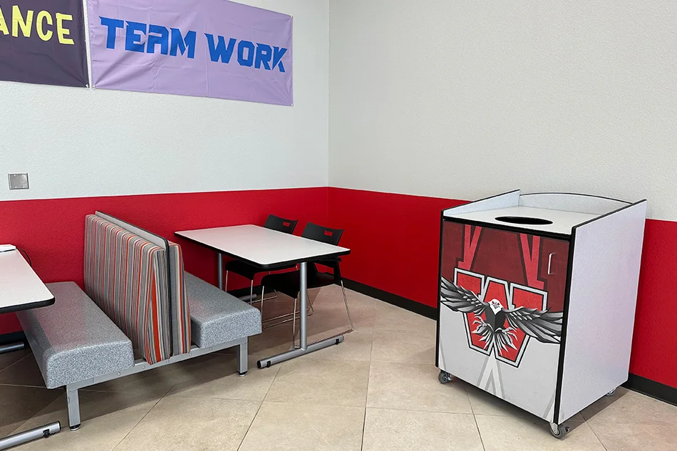 A sitting booth next to a trash can