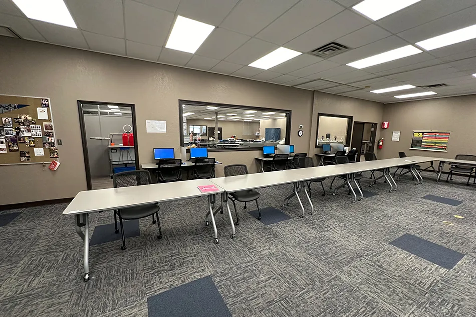 Student tables in front of a window with a large red bulldog decal