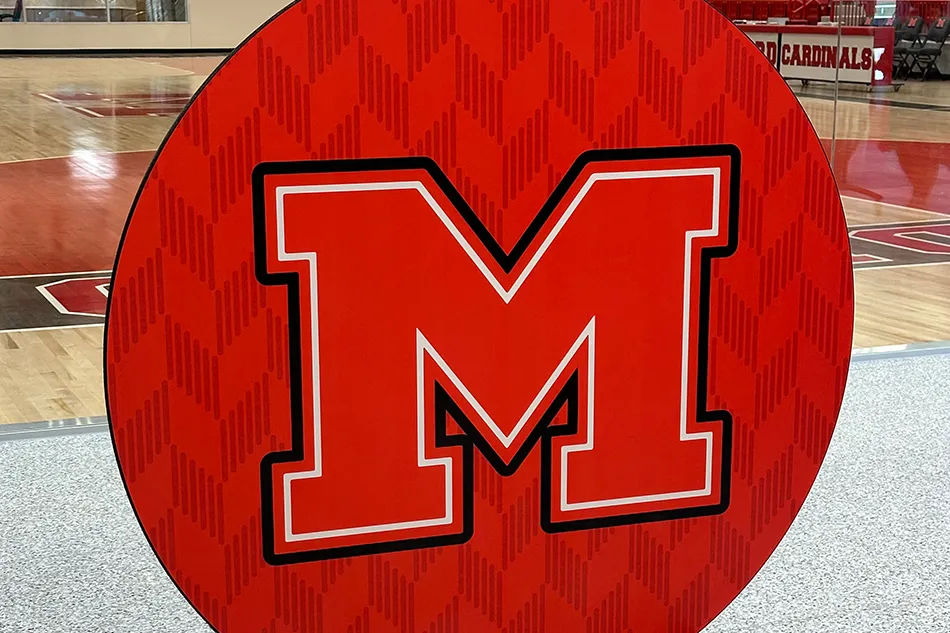 Student tables in front of a window with a large red bulldog decal