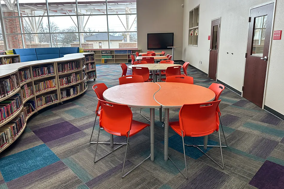 Student tables in front of a window with a large red bulldog decal