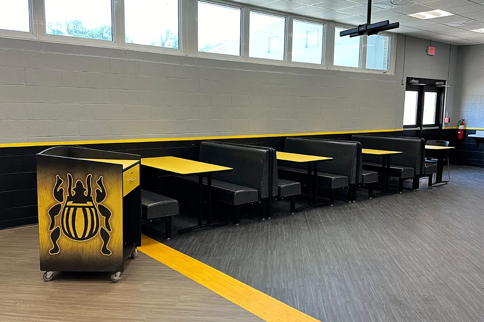 Student tables in front of a window with a large red bulldog decal