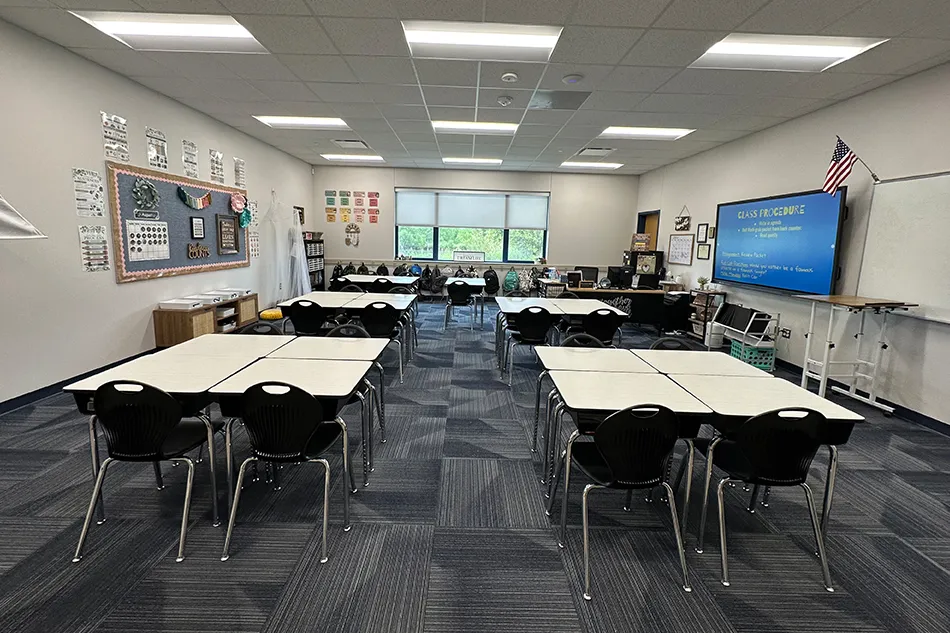 Student tables in front of a window with a large red bulldog decal